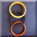 J143. 3 Bakelite bangles in yellow, orange and brown.